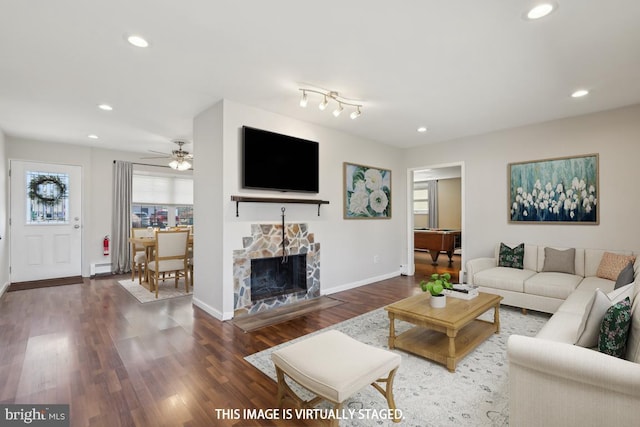 living area with recessed lighting, baseboards, a fireplace with flush hearth, and wood finished floors