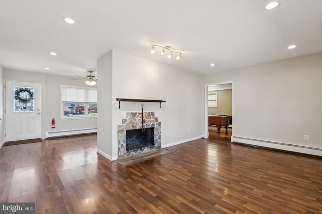 unfurnished living room featuring a stone fireplace, recessed lighting, wood finished floors, and a baseboard radiator