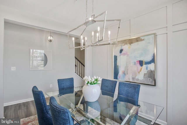 dining space with hardwood / wood-style floors and a notable chandelier