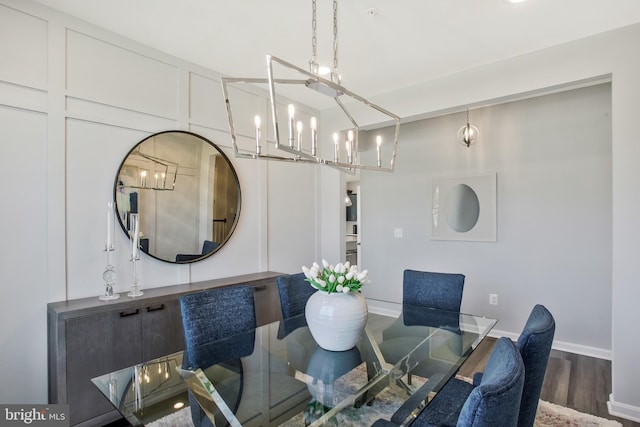 dining space with dark hardwood / wood-style flooring and a chandelier