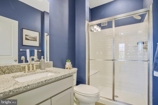 bathroom featuring vanity, toilet, and walk in shower