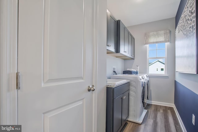 laundry room with cabinets, dark hardwood / wood-style flooring, and washer and dryer