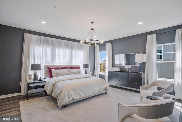 bedroom with hardwood / wood-style flooring, a chandelier, and multiple windows