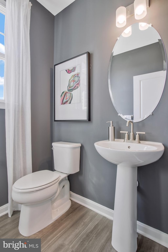 bathroom featuring hardwood / wood-style flooring and toilet