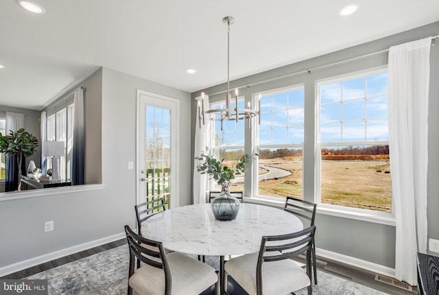 dining space with a notable chandelier and dark hardwood / wood-style floors