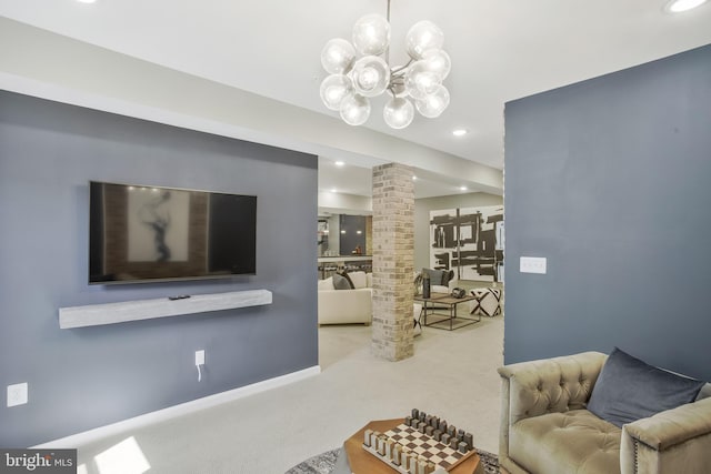 living room with an inviting chandelier, carpet floors, and decorative columns