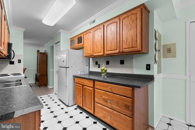 kitchen featuring tasteful backsplash, ornamental molding, and white fridge