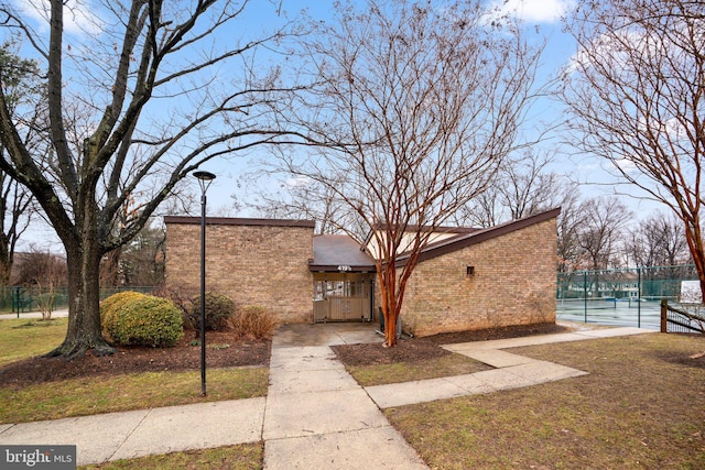 view of front of property featuring tennis court