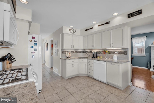 kitchen with white cabinetry, white appliances, and backsplash