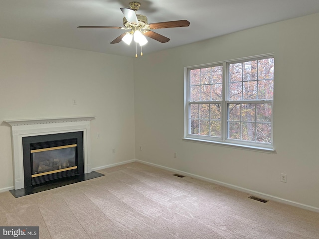 unfurnished living room with light carpet and ceiling fan