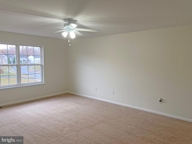 spare room with light colored carpet and ceiling fan