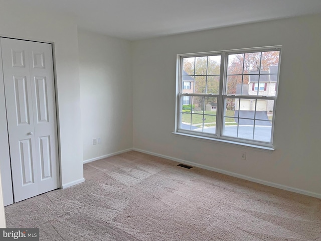 spare room featuring light carpet and a wealth of natural light