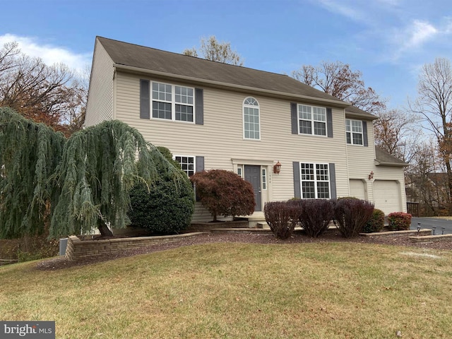 colonial house featuring a garage and a front yard