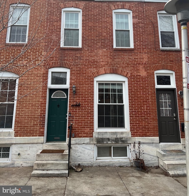 property entrance featuring brick siding