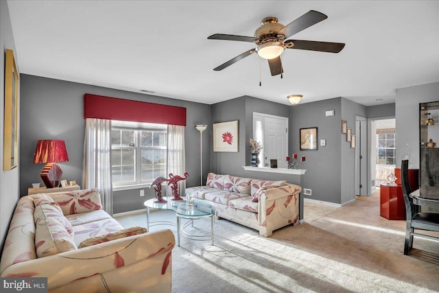 carpeted living room with ceiling fan