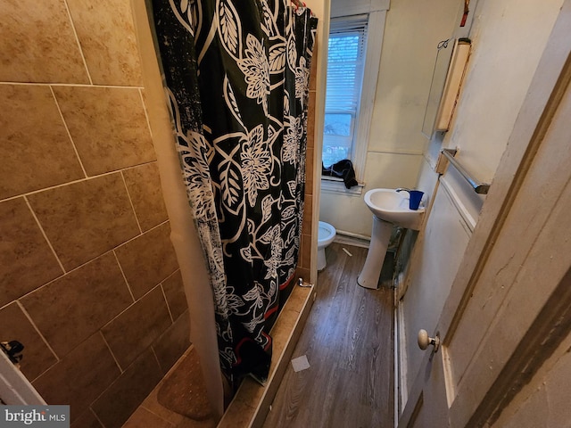 bathroom with a shower with curtain, hardwood / wood-style flooring, and toilet