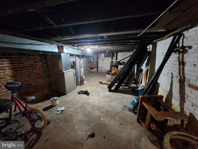 basement featuring brick wall and gas water heater