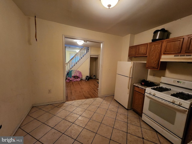 kitchen featuring white appliances and light tile patterned floors