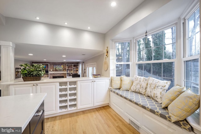 living room with light hardwood / wood-style floors and decorative columns