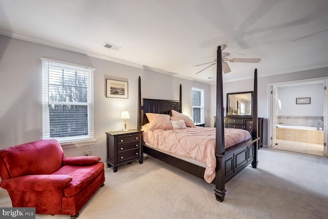 carpeted bedroom with ornamental molding, ceiling fan, and ensuite bath