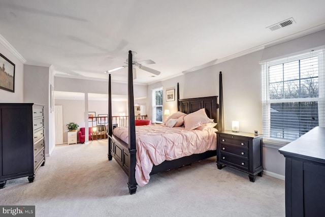 carpeted bedroom with ornamental molding and ceiling fan