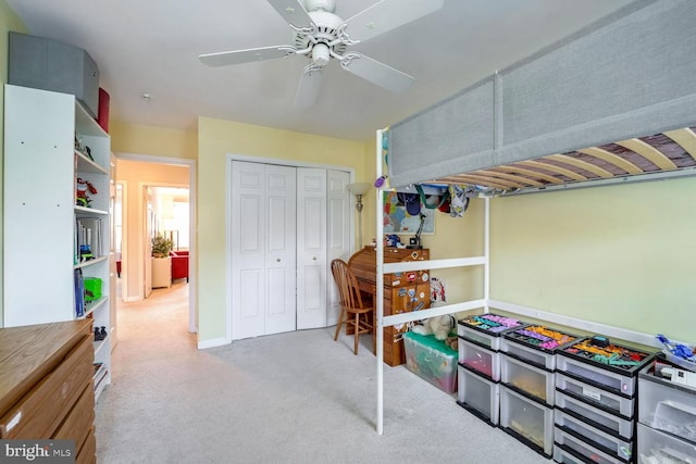 bedroom with ceiling fan, a closet, and light carpet