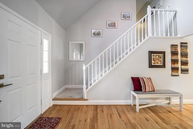 entryway featuring hardwood / wood-style flooring and vaulted ceiling