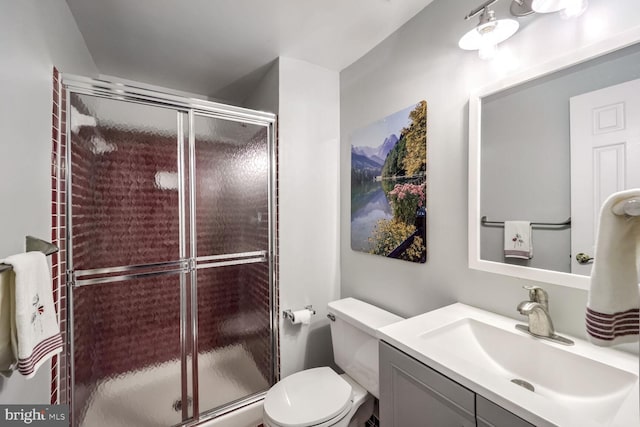 bathroom featuring vanity, toilet, and an enclosed shower