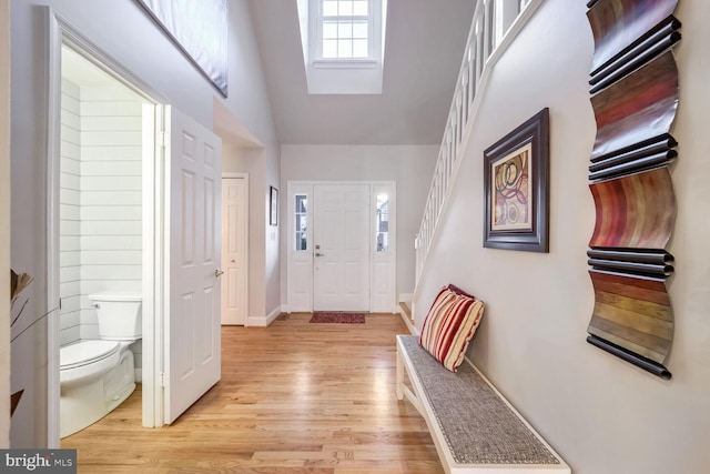 foyer entrance featuring light hardwood / wood-style flooring and vaulted ceiling