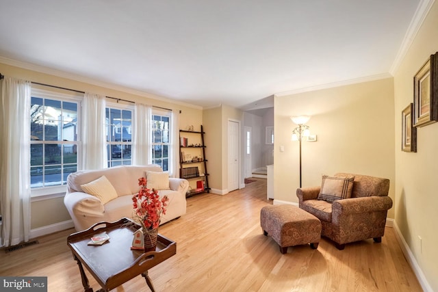 living room with crown molding and light hardwood / wood-style flooring