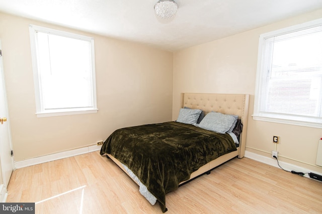 bedroom with light wood-style flooring and baseboards