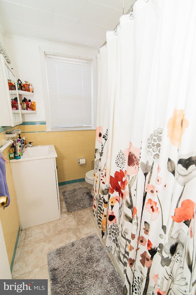 full bath featuring tile walls and vanity