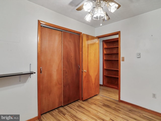 unfurnished bedroom featuring ceiling fan, light hardwood / wood-style floors, and a closet