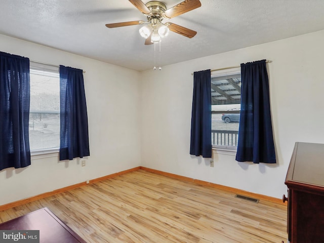 spare room featuring ceiling fan, a textured ceiling, and light hardwood / wood-style floors