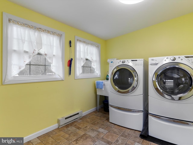 clothes washing area with separate washer and dryer and baseboard heating