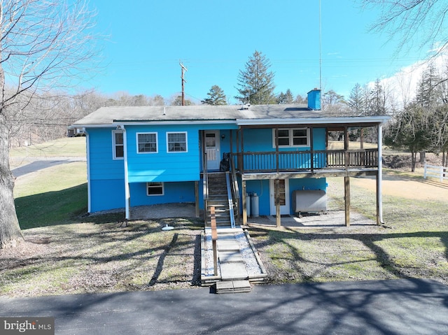 rear view of property with a yard and a deck