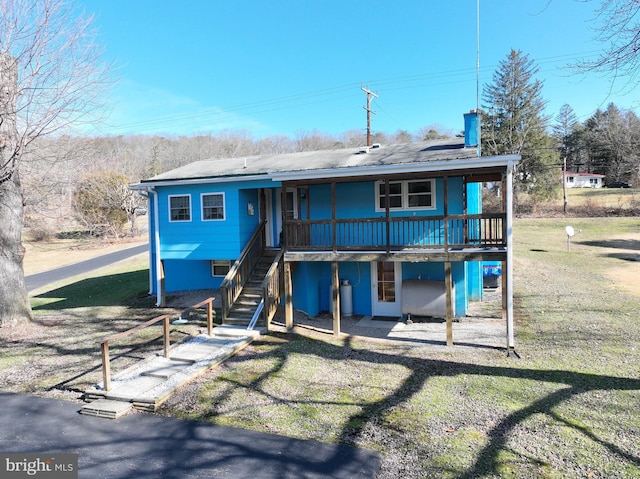 rear view of house featuring a lawn