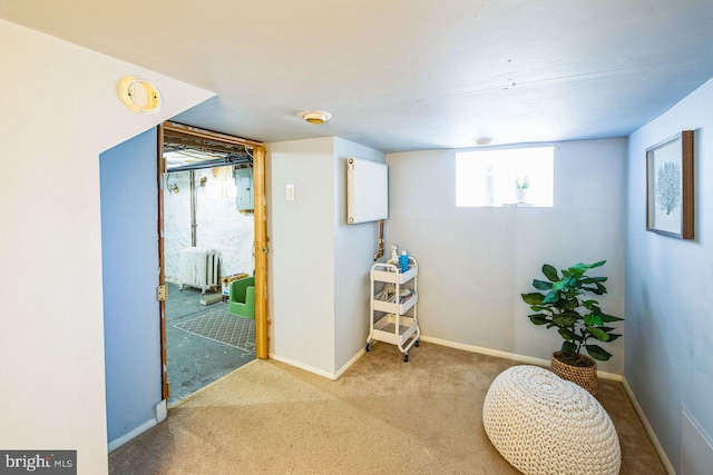 living area with radiator, light colored carpet, and electric panel