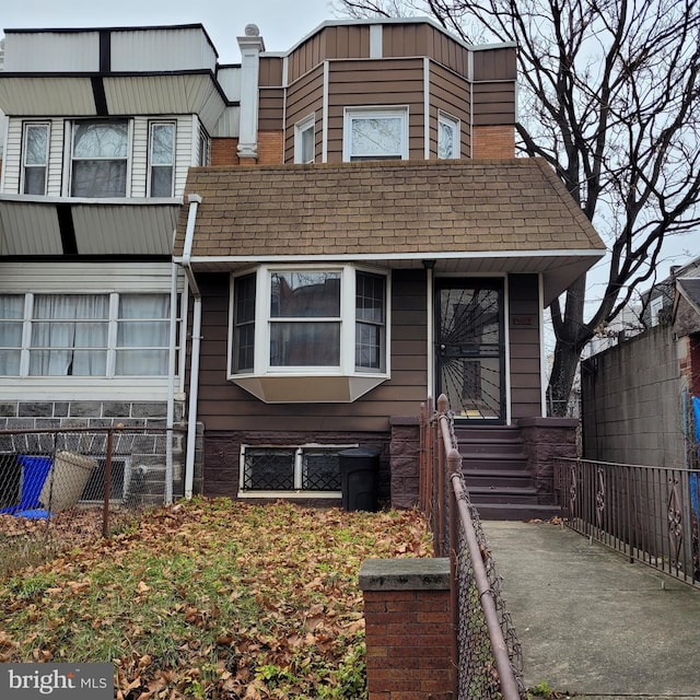 multi unit property featuring fence and roof with shingles