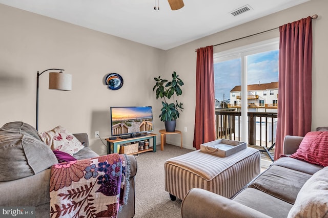 carpeted living room with ceiling fan