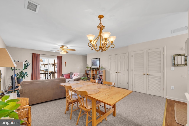 dining space featuring hardwood / wood-style floors and ceiling fan with notable chandelier