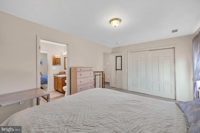 carpeted bedroom featuring ensuite bath and a closet