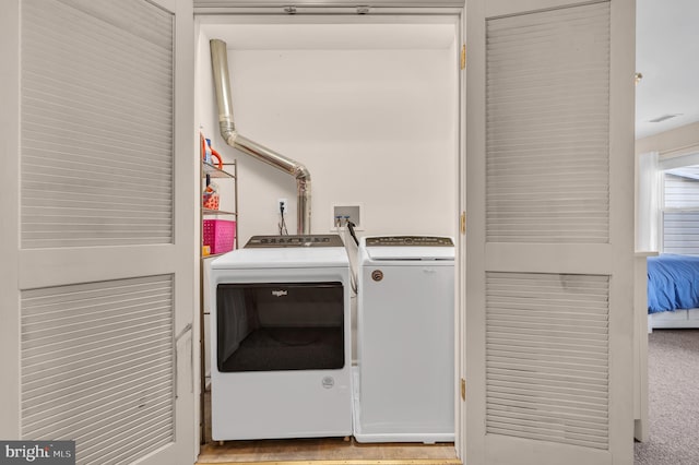 clothes washing area with washing machine and dryer