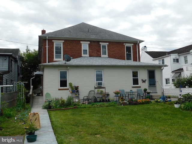 rear view of house featuring a yard