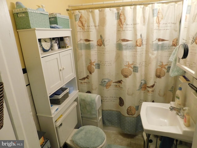 bathroom featuring sink, toilet, and a shower with shower curtain