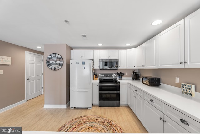 kitchen featuring white cabinetry, stainless steel appliances, and light hardwood / wood-style flooring