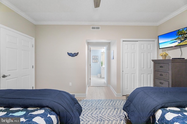 bedroom featuring crown molding, ceiling fan, a closet, and light wood-type flooring