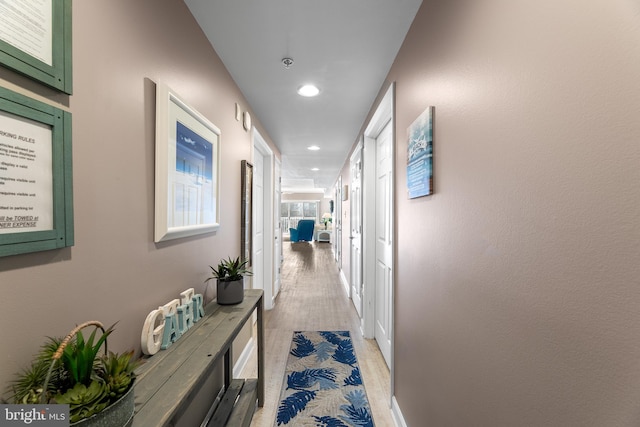 hallway with light hardwood / wood-style floors