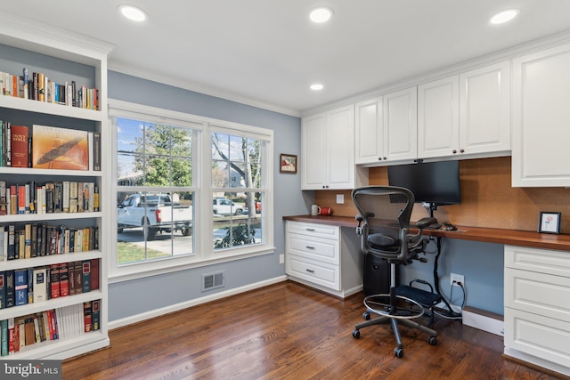 office space featuring built in desk, dark hardwood / wood-style floors, and a healthy amount of sunlight