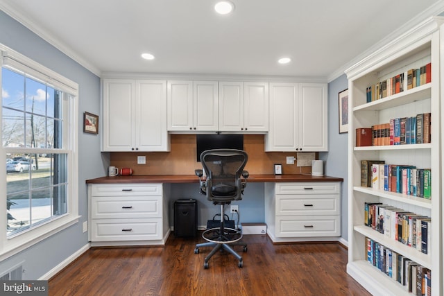 home office featuring built in desk and dark hardwood / wood-style floors